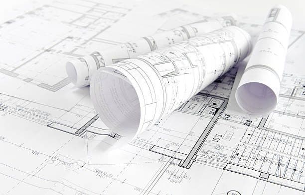 Architectural drawings and rolled blueprints on a desk